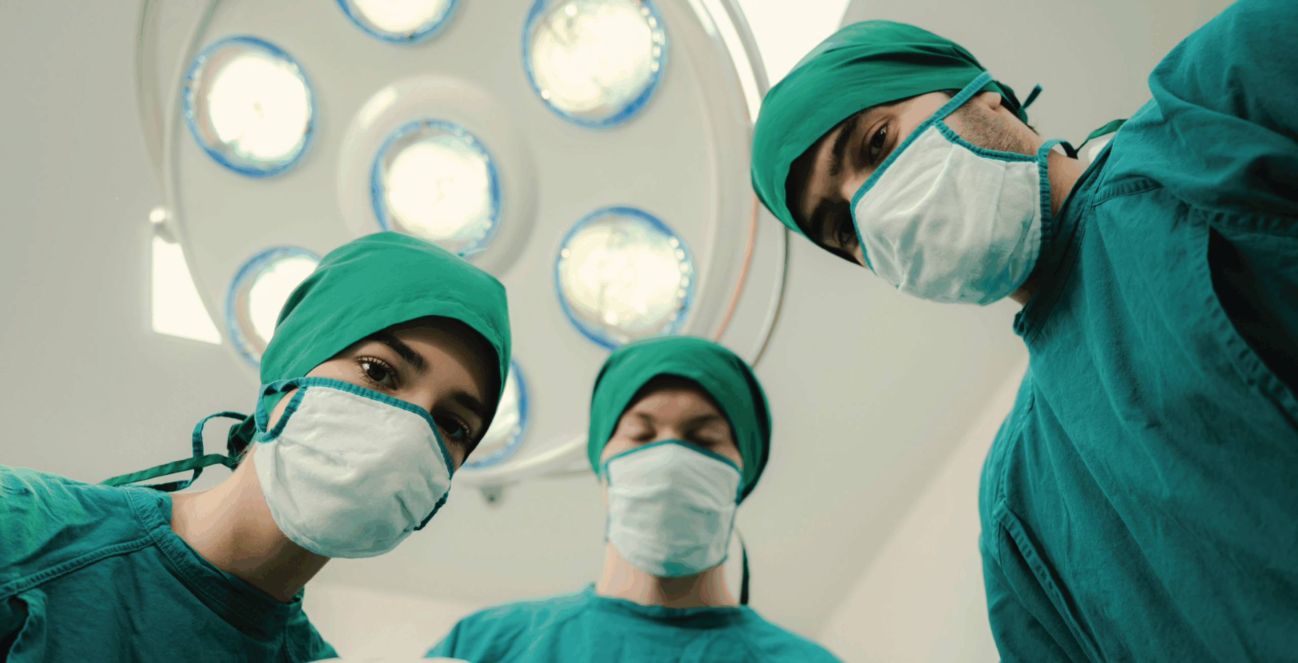 Three surgeons looking at a patient in the operating room