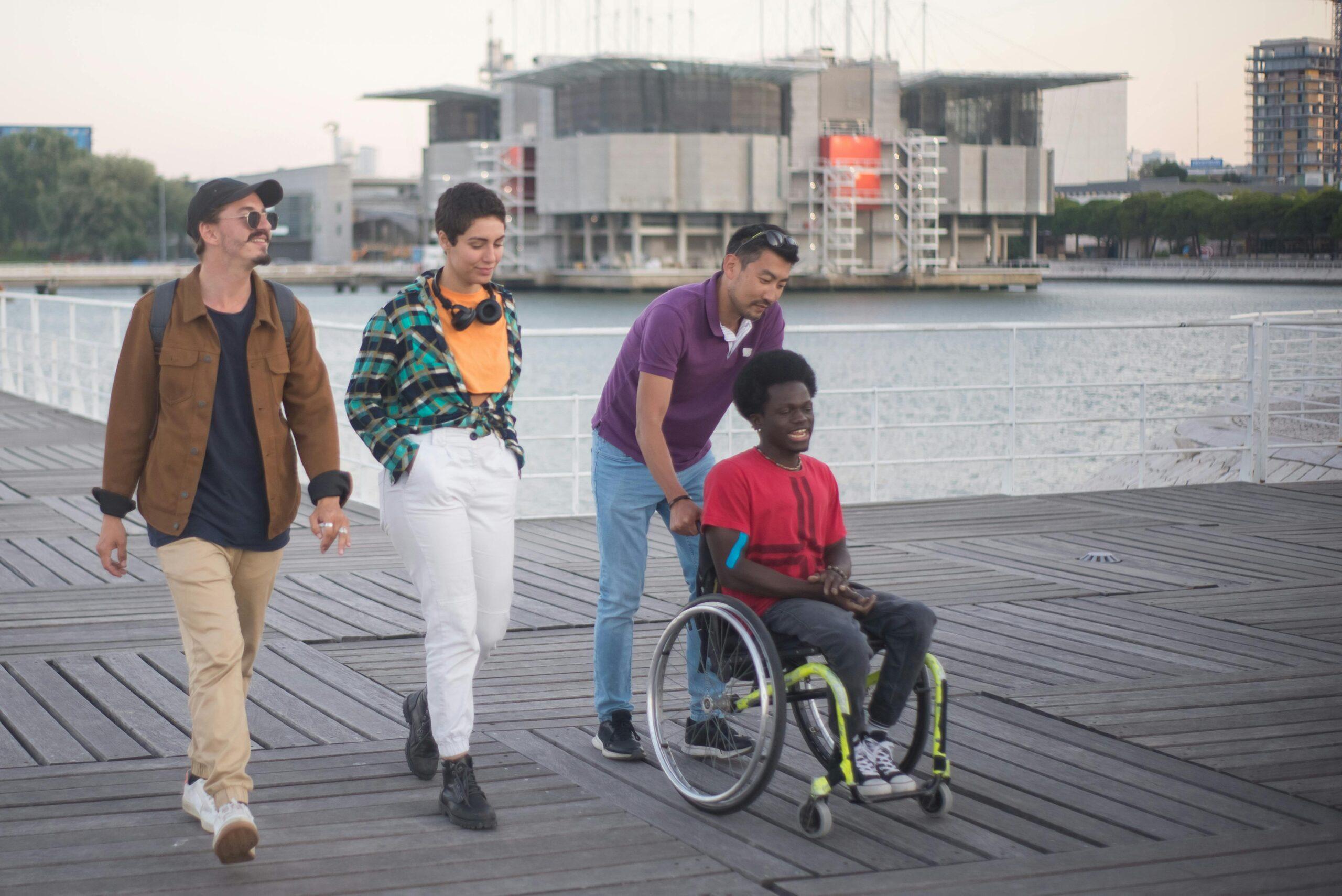 friends pushing man in wheelchair