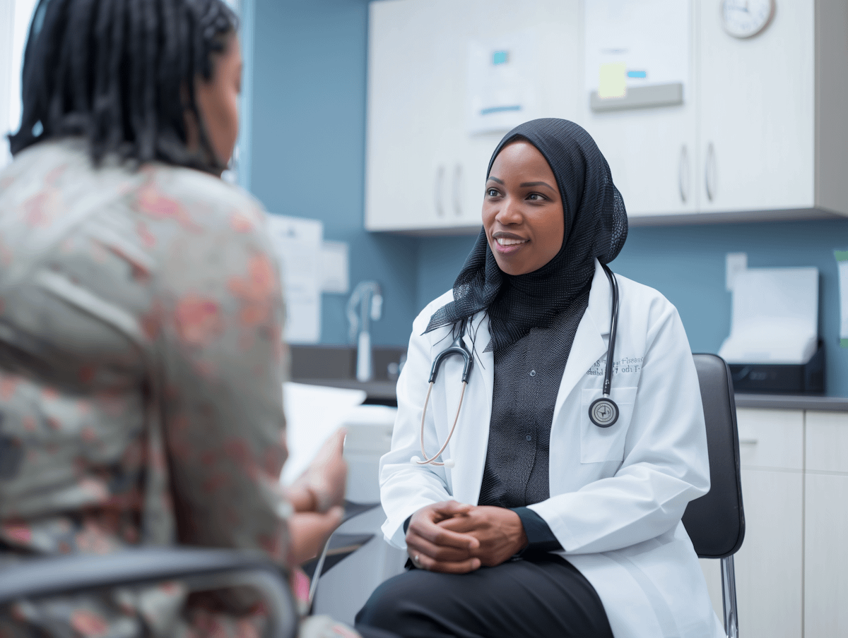 A doctor in a hijab consults with a patient in a medical office